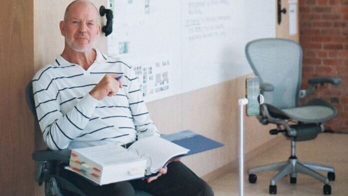 Chip Wilson sitting with a note book